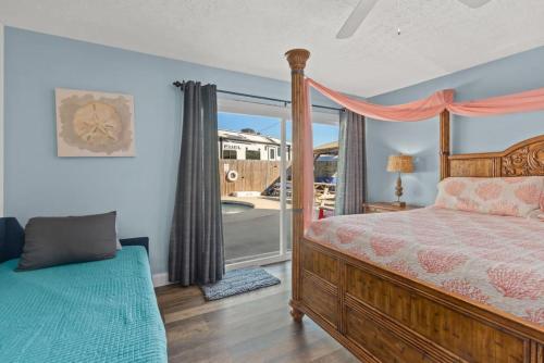 Un dormitorio con una cama y una ventana grande. en Anchors Away - Private Pool, Seasonal Hot Tub, Game Room, Walk to Beach, Pets OK, en Panama City Beach