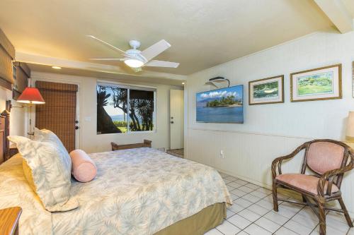 a bedroom with a bed and a ceiling fan at My Waii Beach Cottage home in Kihei