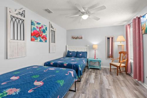 a bedroom with two beds and a ceiling fan at Sand Castle-Pool, Game Rooms, covered outdoor space with tiki bar, 1min walk to beach in Panama City Beach