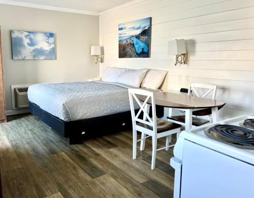a bedroom with a bed and a table and a kitchen at Atlantic Oceanside Dewey in Dewey Beach
