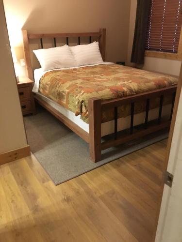 1 dormitorio con 1 cama y suelo de madera en Casa Del Mila Oro en Osoyoos