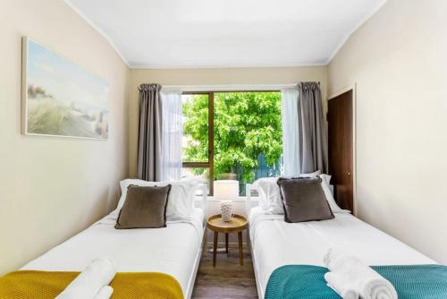 2 camas en una habitación con ventana en Family Retreat close to City - WiFi Netflix Garden, en Auckland
