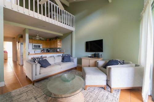 a living room with two couches and a tv at Wicked Wahine Condo in Kahuku