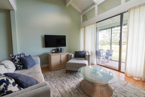 a living room with a couch and a glass table at Wicked Wahine Condo in Kahuku