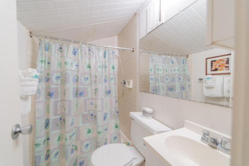 a bathroom with a toilet and a shower curtain at Turtle Bay Sea BreezeNUC 90-TVU-0498 in Kahuku