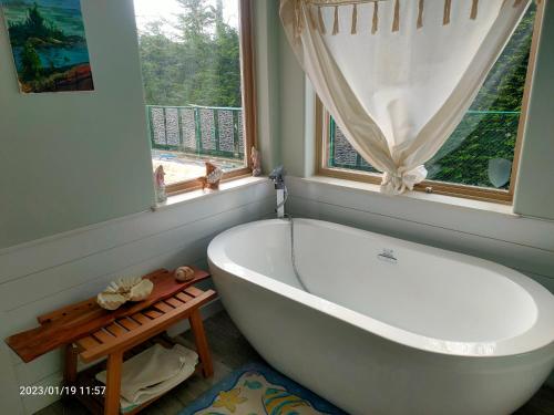a white bath tub in a bathroom with a window at luxury ocean dock pool villa in Ladysmith