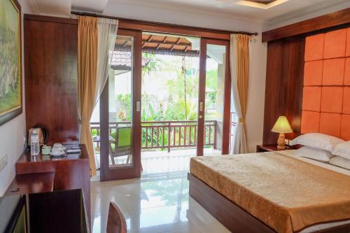 a bedroom with a bed and a balcony at The Gaya in Ubud