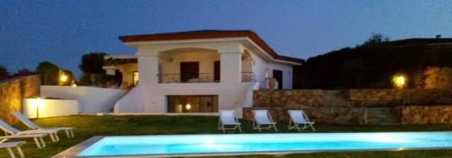 a villa with a swimming pool in front of a house at Villa Smeralda in Palau
