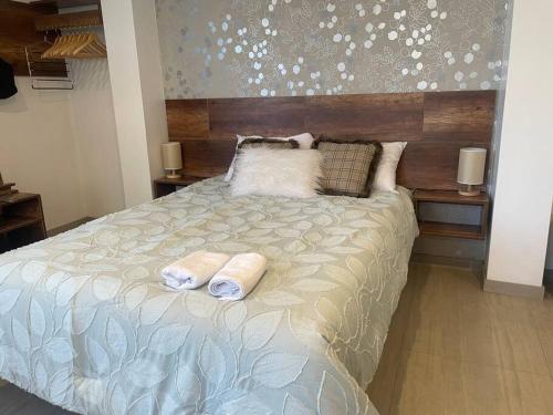 1 dormitorio con 1 cama con 2 toallas en Huancayo Suite, en Huancayo