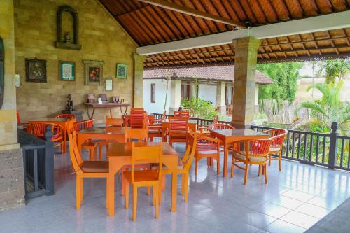 a restaurant with wooden tables and chairs on a patio at The Gaya in Ubud