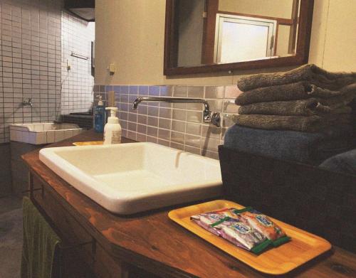 a bathroom with a white sink and a mirror at 囲炉裏町家Guesthouse FUJITA 一棟貸切 villa 無料駐車場 in Hakusan