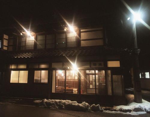a building with two street lights in the snow at 囲炉裏町家Guesthouse FUJITA 一棟貸切 villa 無料駐車場 in Hakusan