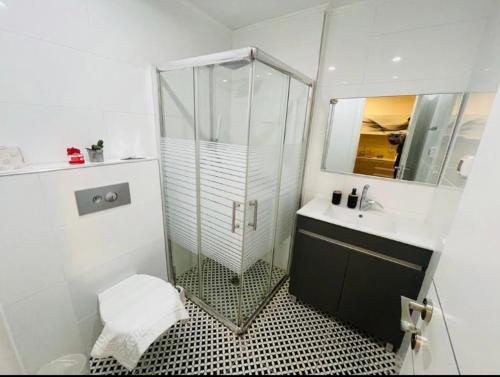 La salle de bains est pourvue d'une douche en verre et d'un lavabo. dans l'établissement BRiGHT AND COZY STUDIO SUiTE EiLAT, à Eilat