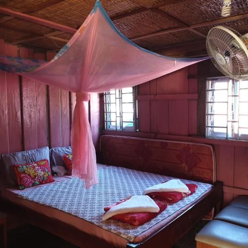 uma cama num quarto com uma rede mosquiteira em Seng Long Guesthouse em Kaôh Rŭng (5)