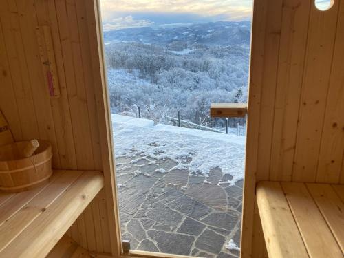 a door to a cabin with a view of the snow at Ferienwohnung Traumaussicht in Leutschach