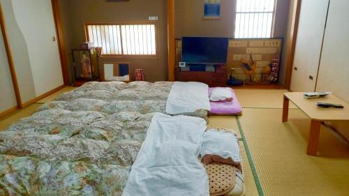 a bedroom with a large bed and a table at Bandai in Tokamachi