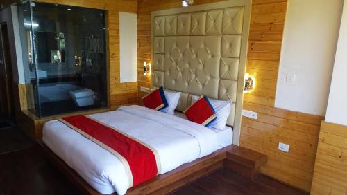 a bedroom with a large white bed with red pillows at Humble Holiday Home Kufri S H I M L A with Lawn and Amazing View in Kūfrī