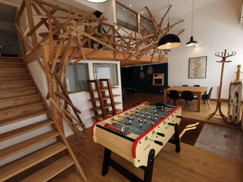 une chambre avec un baby-foot en face d'un escalier dans l'établissement Ancien magasin type loft 145 m2 centre ville, à Boulogne-sur-Mer