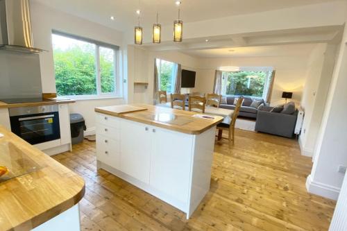a kitchen and living room with a couch and a table at Meadowside, Troutbeck Bridge with offsite health club in Windermere