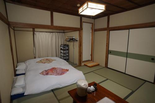 Ryokan Katsutaro في طوكيو: غرفة نوم فيها سرير وطاولة فيها