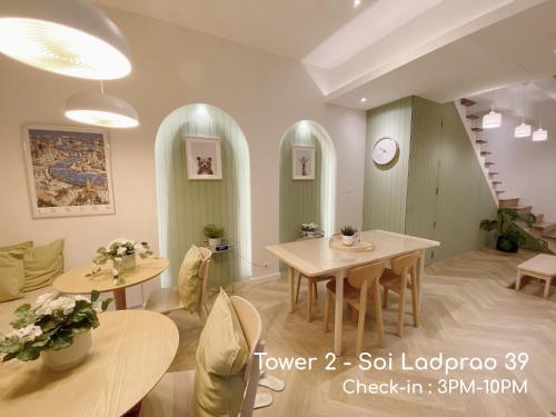 a living room with two tables and a staircase at Double Bed Hotel in Bangkok