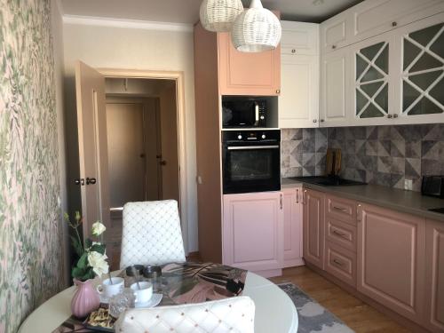 a kitchen with a table and chairs and a counter top at at HOME in Prigorodnyy