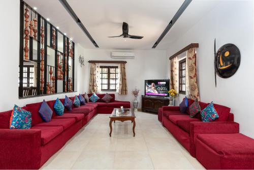 sala de estar con sofás rojos y TV en Villa Calangute Phase 5, en Calangute