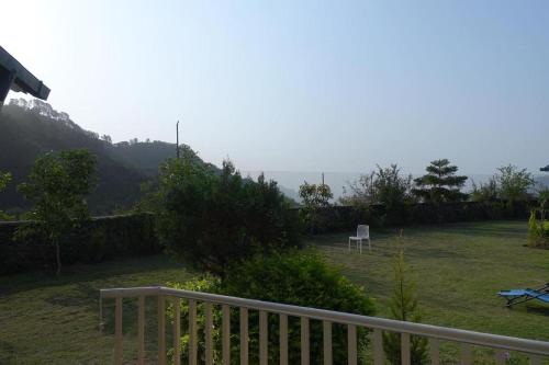 a view of a yard with a fence and a chair at Karinya Villas in Nainital