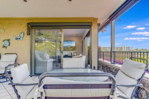 - un balcon avec un lit et des chaises sur une terrasse couverte dans l'établissement WAILEA ELUA, #0105 condo, à Wailea