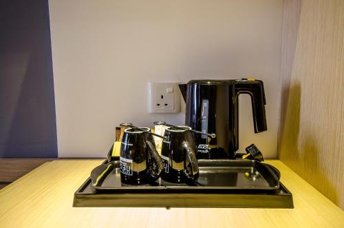 a black coffee maker sitting on top of a stove at Neo+ Penang in George Town