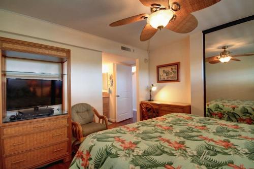 een slaapkamer met een bed en een flatscreen-tv bij SUGAR BEACH RESORT, #329 condo in Kihei