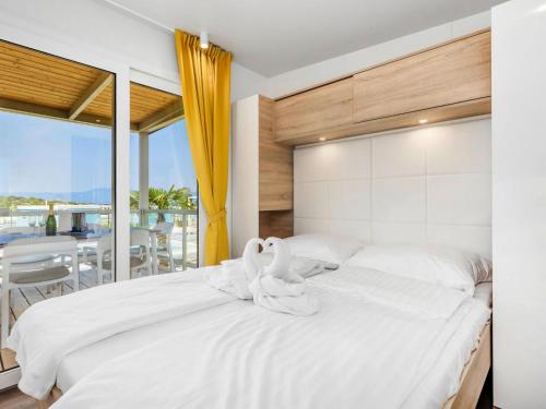 two white swans sitting on a bed in a bedroom at Mobile Homes in Camping Omisalj, island Krk, with swimmingpool in Omišalj