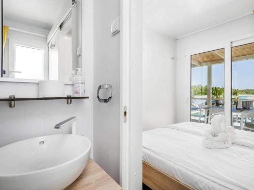 a white bathroom with a sink and a tub at Mobile Homes in Camping Omisalj, island Krk, with swimmingpool in Omišalj