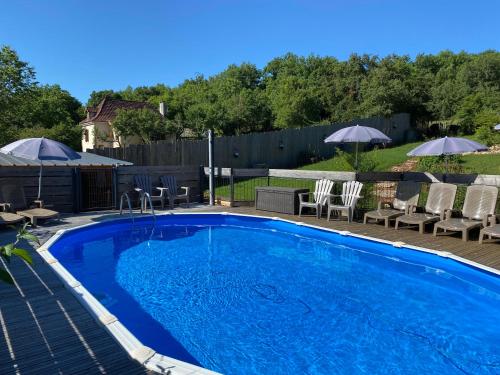 einen Pool mit Stühlen und Sonnenschirmen im Hof in der Unterkunft Jacuzzi privatif pour 2 dans le Lot à 1h30 de Toulouse Rodez Brive in Calvignac