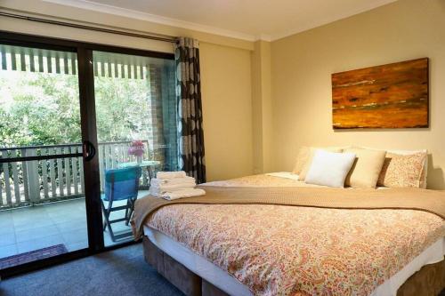 1 dormitorio con 1 cama y balcón en Cloudland Garden Oasis, en Blackheath