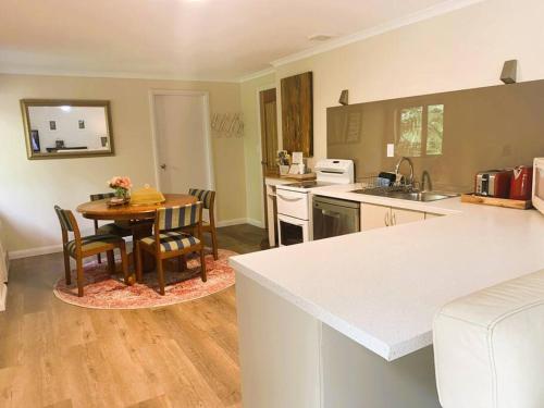 a kitchen and dining room with a table and chairs at Cloudland Garden Oasis in Blackheath