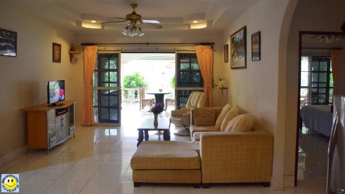 ein Wohnzimmer mit 2 Sofas und einem TV in der Unterkunft Smile House & Pool in Rawai Beach
