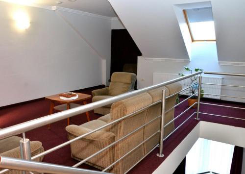 Cette chambre dispose d'un escalier, de chaises et d'une table. dans l'établissement Belvárosi Vendégház, à Mór