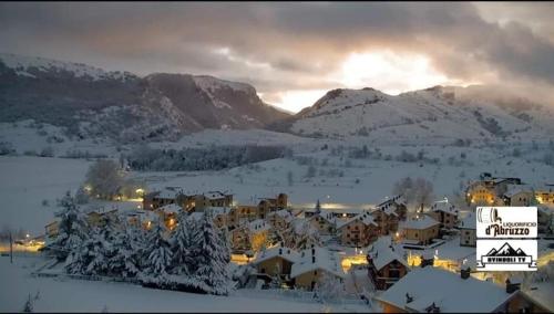 un villaggio ricoperto di neve con montagne sullo sfondo di L' incantevole Tana di Oto a Ovindoli