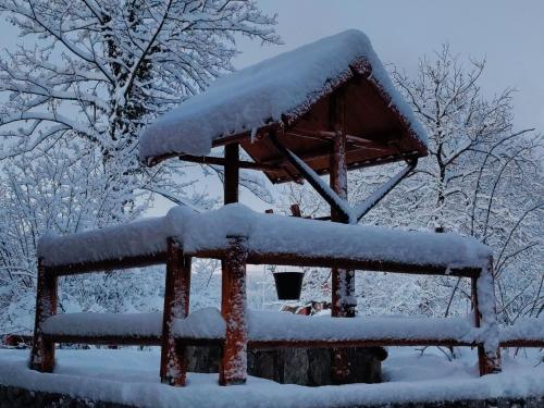 a snow covered bird house with a roof at Brunarica Biopark -Log house Biopark in Grosuplje