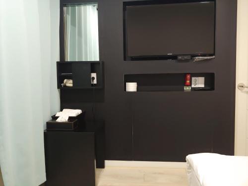 a bedroom with a black wall with a flat screen tv at Korea guesthouse in Gumi
