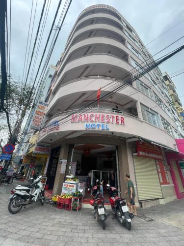 a building with two motorcycles parked in front of it at Anh Minh - Manchester Hotel Tran Phu Beach Nha Trang in Nha Trang