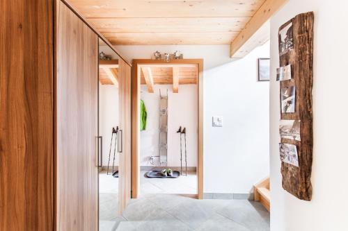 a pivot door opens up a hallway to a home with wood ceilings at Chalet Hinter Dem Rot Stei in Zermatt