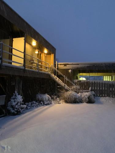 a building with snow on the ground and a staircase at Le Petit Logis in Jalhay
