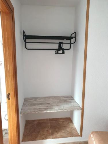 a shelf in the corner of a room with a mirror at Hostal Fronton in Alcobendas