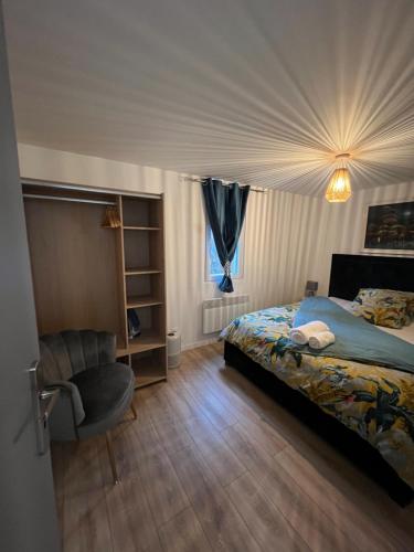 um quarto com uma cama e uma cadeira em Le cocon du centre ville em Saint-Dizier