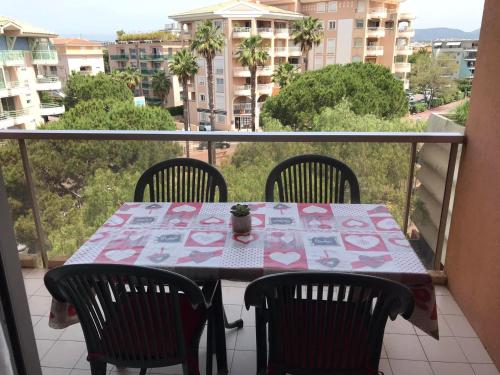 stół i krzesła na balkonie z widokiem na miasto w obiekcie Appartement en front de mer avec parking privatif w Fréjus