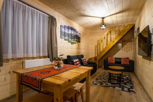 Cette chambre dispose d'une table en bois et d'un canapé. dans l'établissement Willa Mała Łąka, à Zakopane