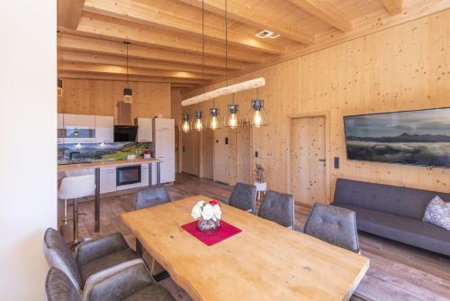 a kitchen and dining room with a wooden table and chairs at Heustadl Zillertal in Zell am Ziller