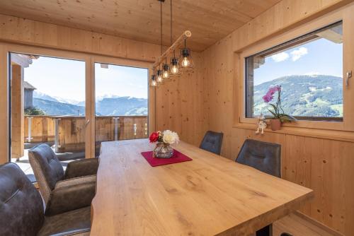 a dining room with a table and chairs and windows at Heustadl Zillertal in Zell am Ziller